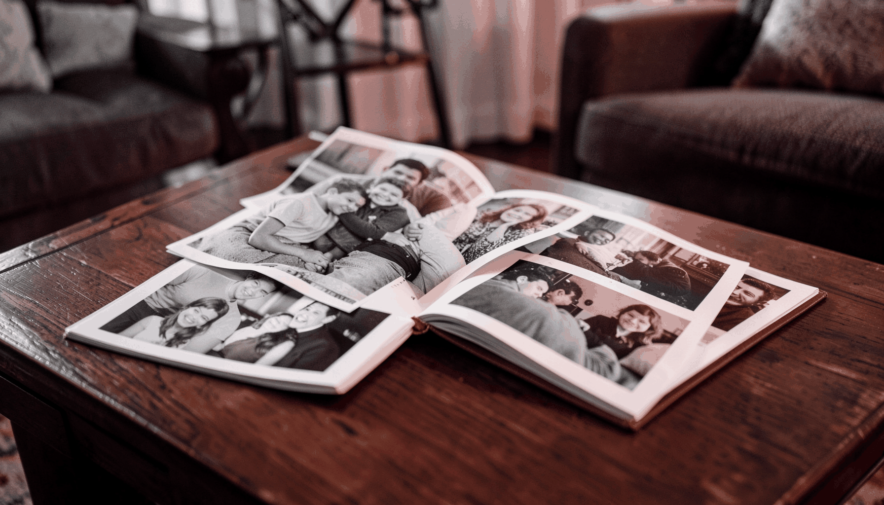 A family photo album open on a coffee table, candid snapshots spilling out, cozy living room